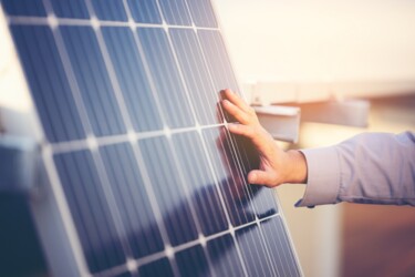 Hand streicht über Solarpanel