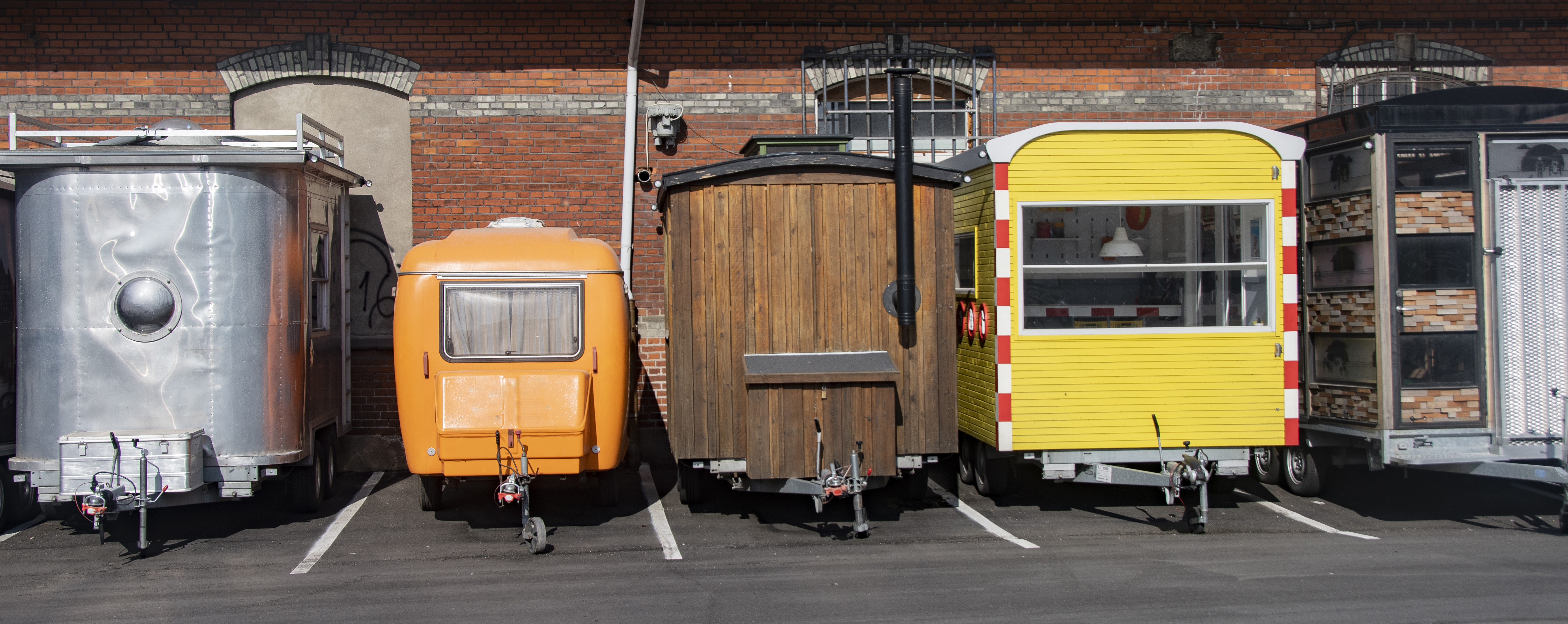 Mehrere Wohnwagen mit verschiedenen Designs parkend auf einem Parkplatz